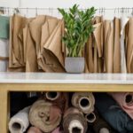 Job Market - Rolls of assorted fabrics and textiles and sewing patterns inside tailor atelier