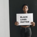 Inclusion - A Woman Holding a Card with Words Black Lives Matter